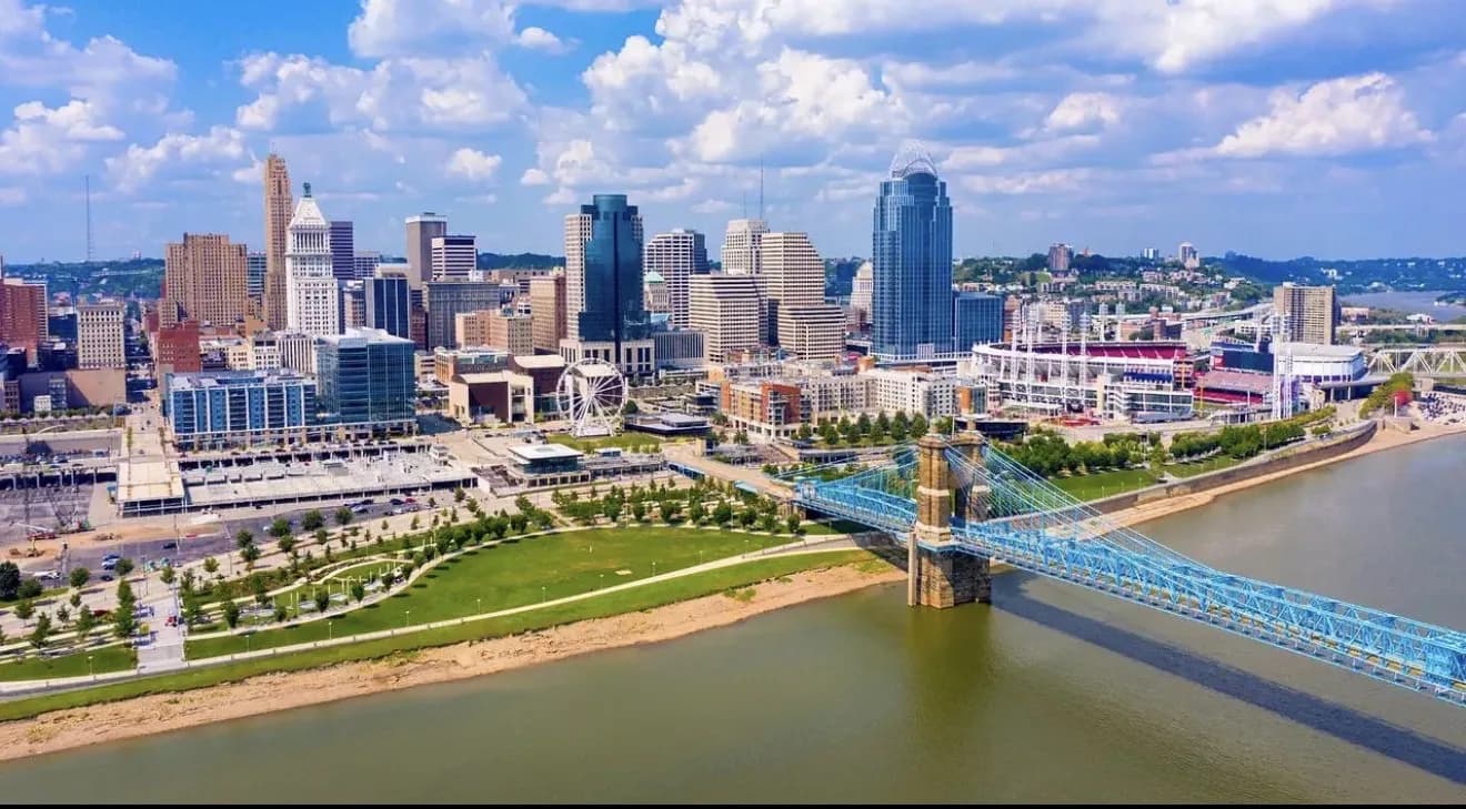 Cincinnati skyline along the Ohio River with the Roebling Bridge and riverfront park