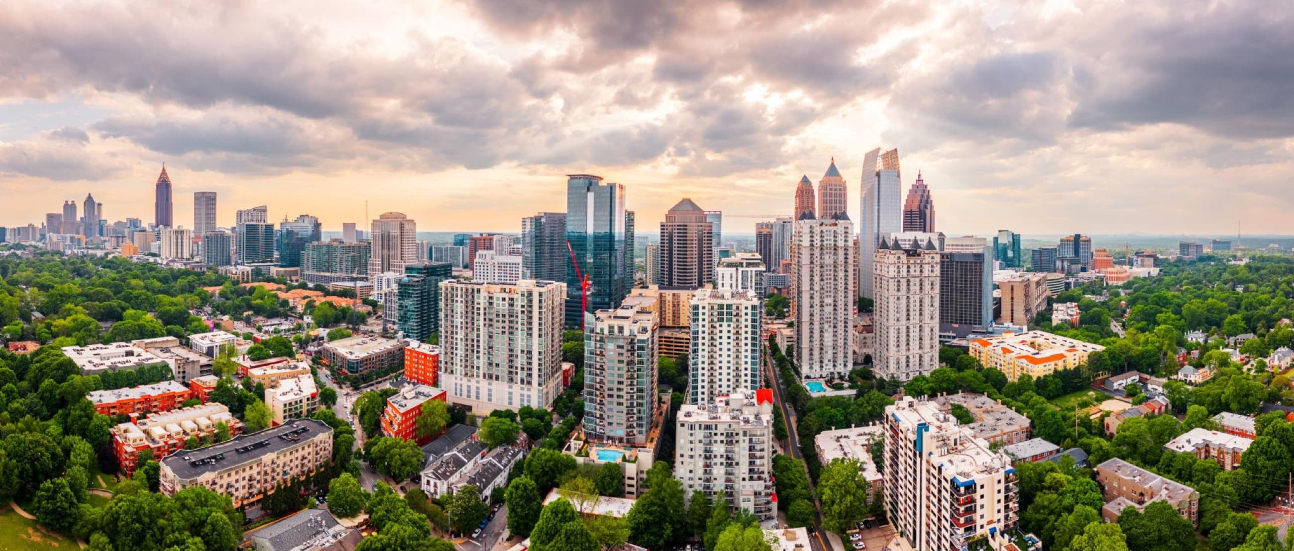 A broad city skyline beneath warm evening clouds