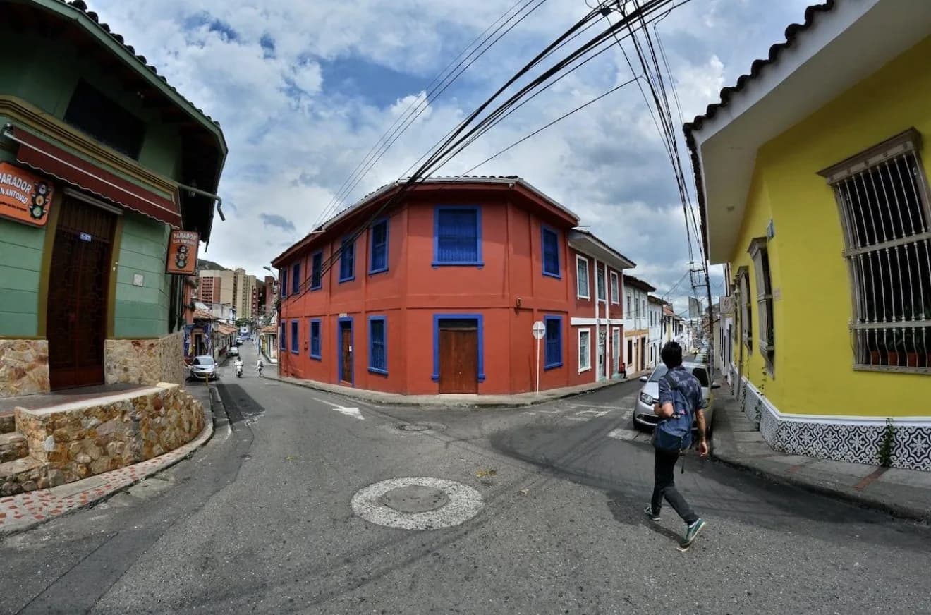Colorful street corner in Cali, Colombia with a distinctive red building at an intersection